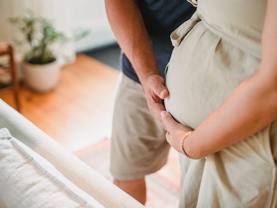 Kobieta w ciąży i mężczyzna dotykający jej brzucha