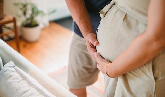 Kobieta w ciąży i mężczyzna dotykający jej brzucha